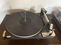 Front angle of Dual 1010 turntable showing platter and tonearm with cartridge sled included.