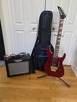 Full view of guitar, amp, gig bag, strap and cables