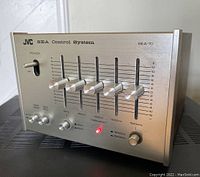 Front view of JVC SEA-10 equalizer with sliders, knobs, power toggle and lit red LED light indicating power on.