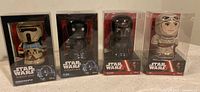 Front view of the four Star Wars tin wind-up toys in original packaging showing Stormtrooper, K-2SO, Kylo Ren, and Rey characters.