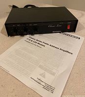 Front view of Bogen Classic Series public address amplifier Model C-10 showing control knobs and power switch next to original user manual.