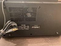 Bottom view showing power cord, ventilation slots, and Sony label with model information and caution warning.