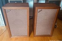 Front view of two Vintage Coral speakers showing wood cabinets and beige grill cloth with Coral badges.