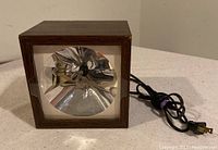 Front view of vintage Archer strobe light showing wooden case and reflective cone interior behind glass.