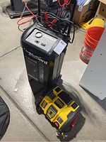 Overview of DieHard charger/starter and Stanley inverter/charger side by side in basement