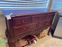 Full view of wooden 5-drawer buffet showing rich reddish-brown finish, ornate wood carvings on legs and apron, and brass handles on drawers.