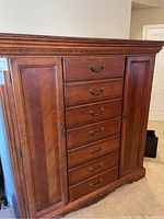 Front view of chest/cabinet showing seven central drawers and two closed side cabinet doors
