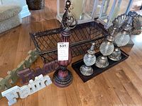Photo showing the metal baskets, decorative bottles, and tall pedestal with ornate metal finial.