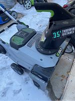 Side view of snowblower showing chute, wheels, and body