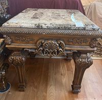 Front view showing faux stone tile top and carved wood base