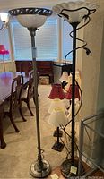 Pair of contemporary floor lamps together in an indoor room with dining furniture visible in background.