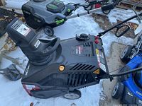 Front angled view of Craftsman snowblower showing intake chute and auger area, controls and wheels, on snowy ground.