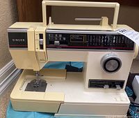 Front view of beige Singer portable sewing machine showing stitch selection panel and handle.