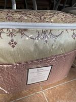 Comforter set packaged in quilted rose-pink storage bag with label.