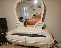 Front view of the white Art Deco style bedroom dresser with large curved mirror, showing the two drawers and black marble-like inset top surfaces.