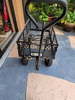 Front-facing photo of the heavy duty steel garden trolley cart with black perforated steel sides and bottom, pneumatic tires, and handle.