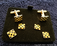 Four square checkerboard pattern cufflinks on black display, black and gold colors