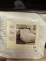 Photo of packaged bedspread set label showing 8 piece quilted bed ensemble with image of assembled bed and components.