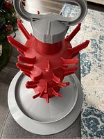 Overview of the bottle drying rack showing red pegs and gray base with handle