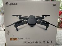 Front view of the Eachine ES8 drone box detailing foldable quadcopter drone with camera and Wi-Fi features, recommended for ages 14+