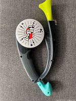 Top-down view of Bop It game showing speaker with logo and yellow bopper and turquoise trigger controls on gray body.