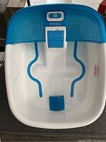 Top-down view of the Homedics foot bath showing control button, blue textured foot massage areas and rollers