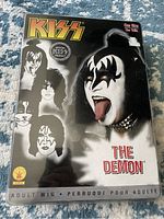 Original packaging of officially licensed KISS The Demon adult wig with band member artwork and labeling.