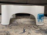 Front view of the white Squatty Potty original model plastic footstool with label and brand visible.