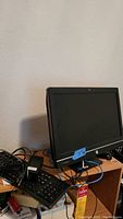 Side view of HP 21-inch monitor and HP Pro 600 desktop with keyboard, power adapter, and cables on wooden desk.