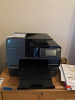Front view of HP Officejet Pro 8630 printer with paper tray extended, touchscreen display visible, and HP branding.