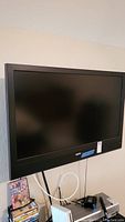 Front view of black Sanyo 46-inch TV mounted on a wall, showing full screen and bezel.