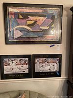Photo showing one large modern abstract framed painting and two smaller African art prints below.