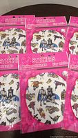 Six unopened packs of Batman and Robin themed stickers featuring iconic characters in multiple poses inside pink packaging.