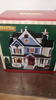Photo of the original box showing Lemax Hillsview Inn Christmas village building with Christmas decorations and holiday wreaths.