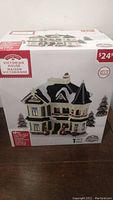 Box showing the Holiday Time Victorian House Christmas Village Building with price tag $24.99