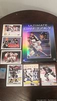 Photo showing one Ultimate Gretzky DVD case with six hockey cards arranged around it
