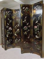 Full view of six-panel black lacquer folding screen decorated with stone inlay bird and flower scenes.