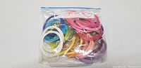 Clear resealable bag containing various colors of thin plastic strings for art and craft usage.