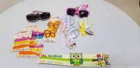 Overview photo showing all kids fashion accessories including sunglasses, hair clips, headbands, and hair ties on a white surface.