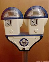 Full front view of dual-head parking meter with Maple Leafs logo