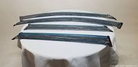 Four smoke-tinted semi-transparent window visors laid out on a white surface.