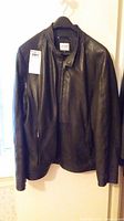 Full front view of jacket hanging on hanger against wall