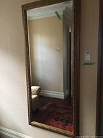 Full view of large rectangular mirror hanging on wall, showing frame and reflection.