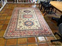 Full view of rug on tile floor, showing overall design and color