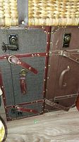 Two-toned dark and medium brown suitcase with leather trim, metal latches and rivets visible