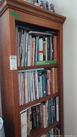 Photo showing entire wooden bookcase filled with books, highlighting the size and condition.