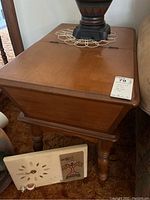 Top and side view of the lift top wooden end table showing minor wear and hinge top.