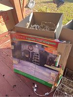 Box labeled 'Spiral Lighted Tree Sculpture' with lights and wire parts visible inside