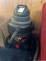 Photo of black Shopvac with hose attached, dusty but intact, labeled 10 gallon, model SP Quiet 10.