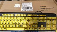 Yellow and black EZ Eyes keyboard on top of shipping box